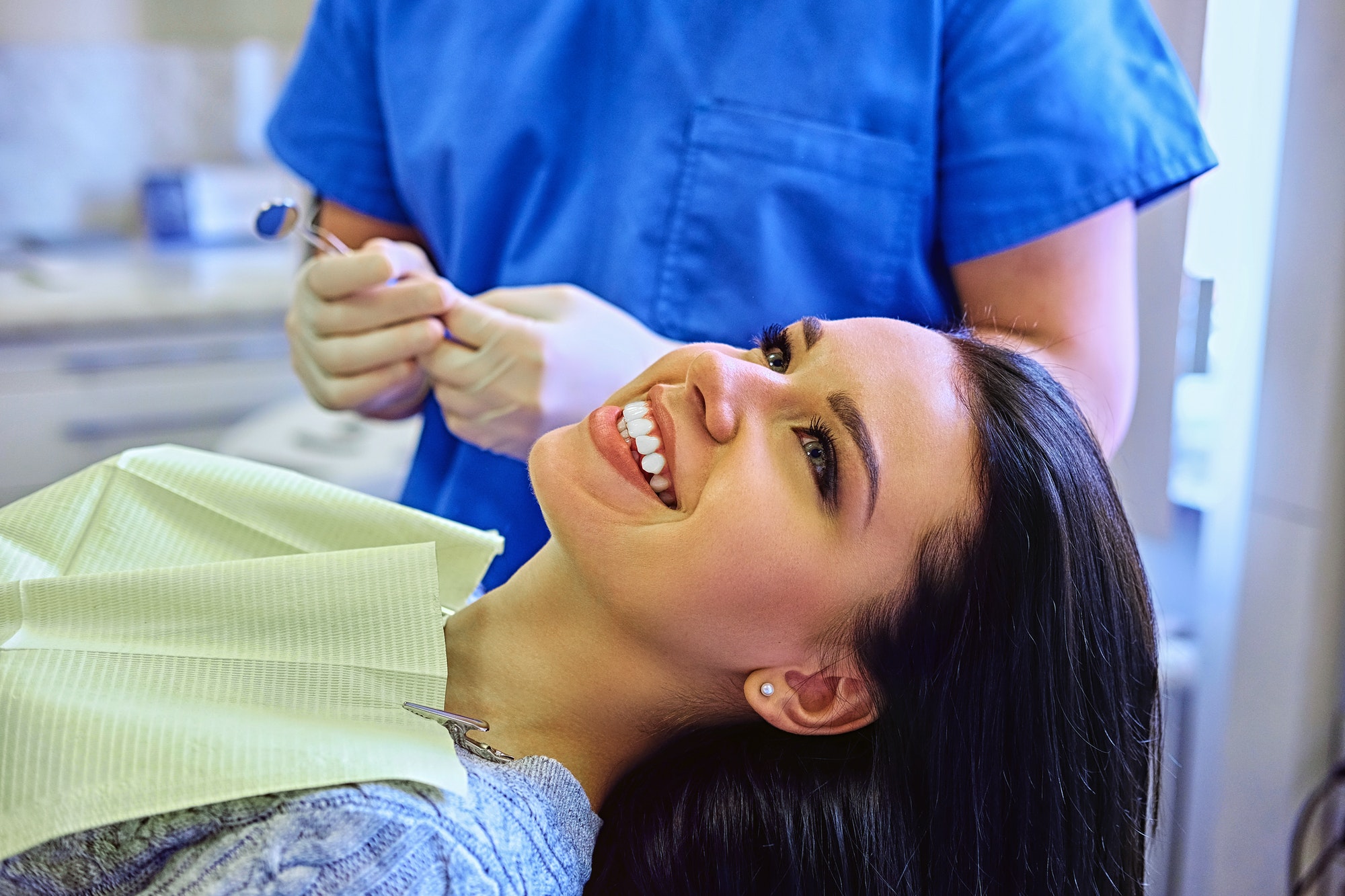 Dentist examining female's teeth in dentistry.